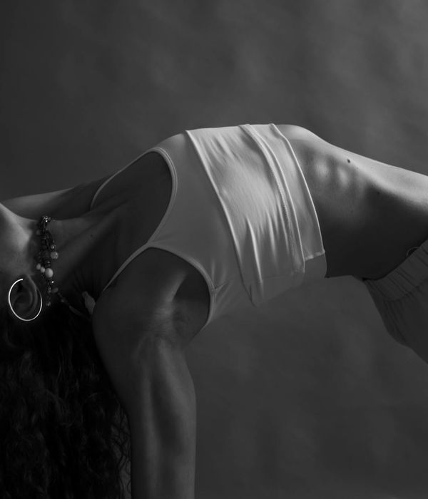 Person in a graceful yoga pose with mint light accents.